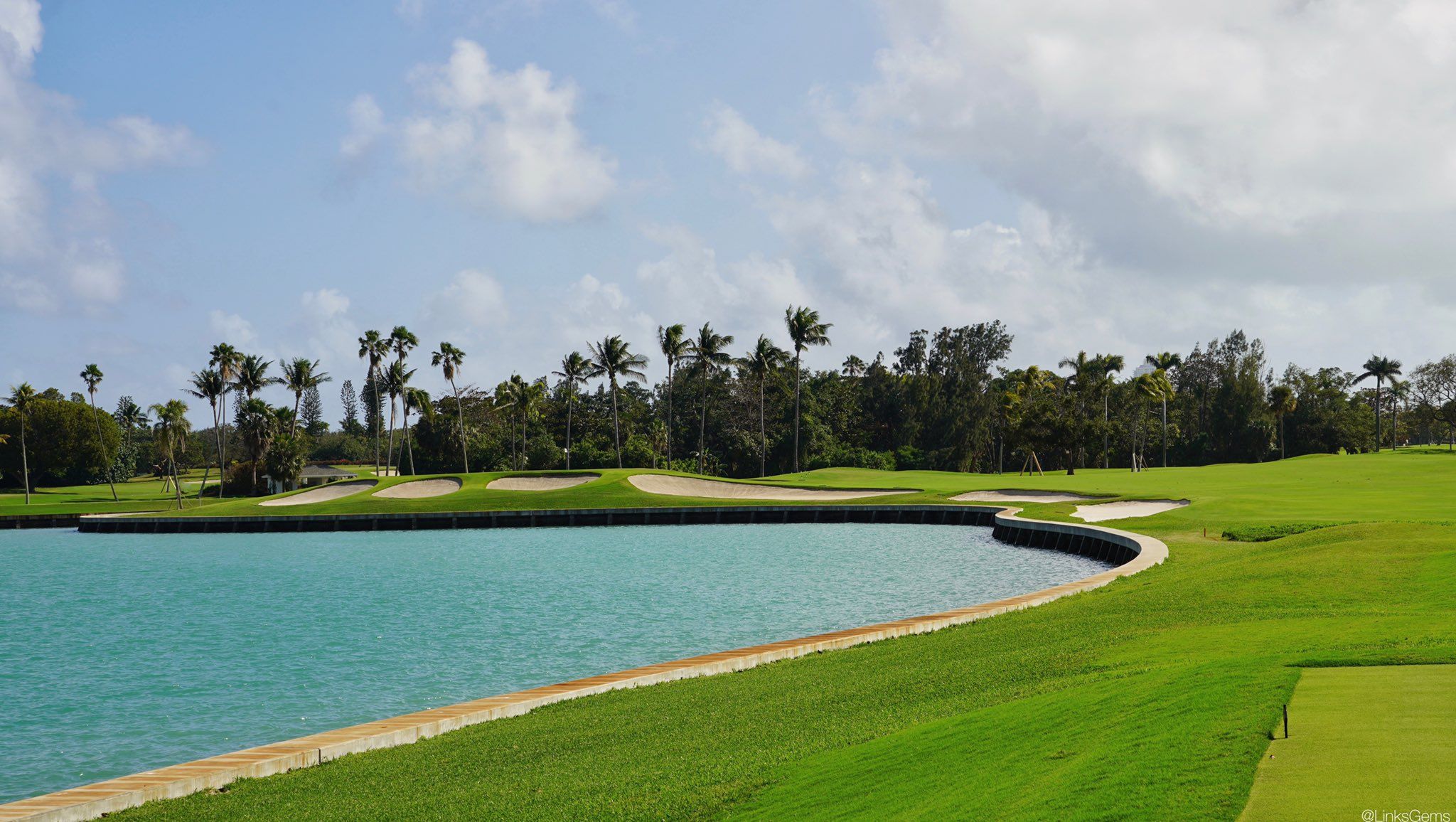The golf course features a large lake and numerous trees
