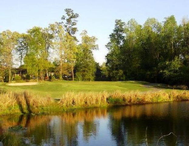 on the golf course there are a lake and lot of trees