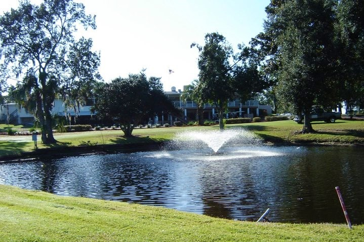 There is a lake with a fountain and a golf club on the golf course - Crystal River Golf Club