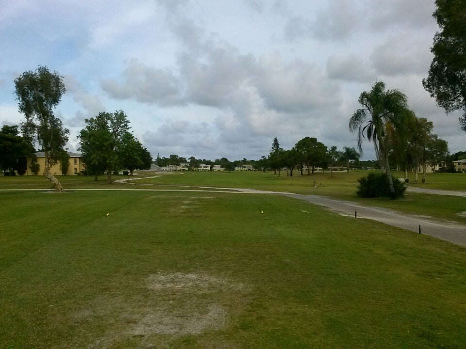 There are numerous homes and trees on the golf course
