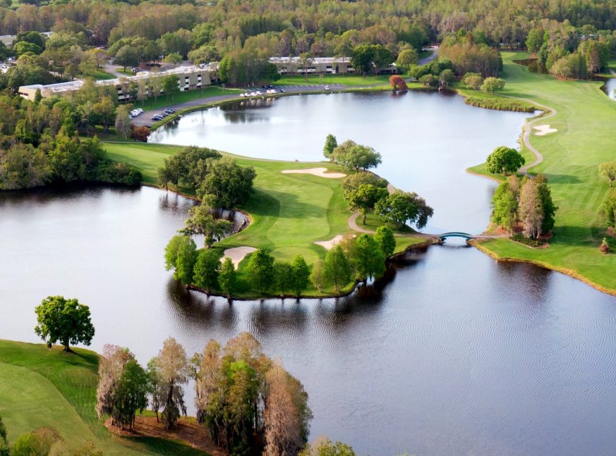 There are many golf clubs and a lake on the golf course, as well as many trees - Innisbrook Golf Resort