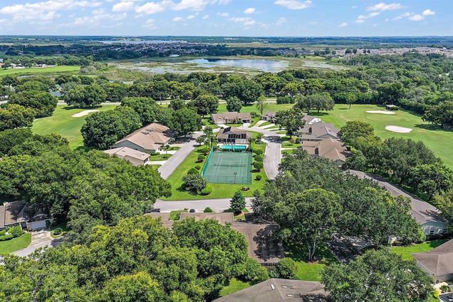 There are many homes and a tennis court on the golf course, as well as many trees - Green Valley Country Club
