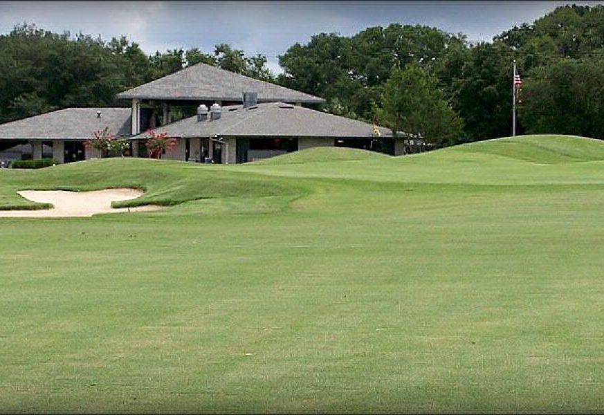 on the golf course there are a clubhouse - Pine Oaks of Ocala