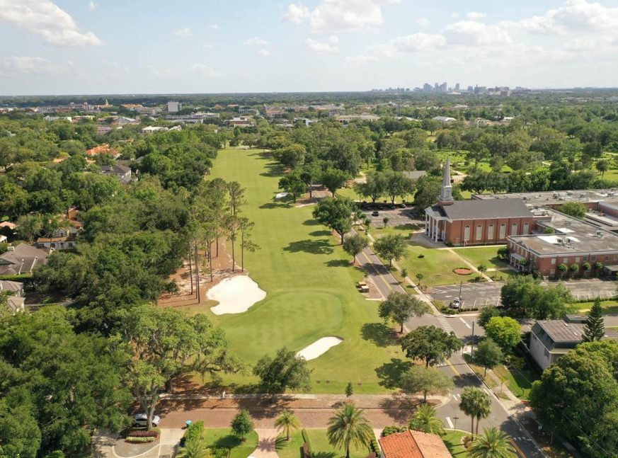 The golf course is surrounded by trees and houses. - Winter Park Golf Course