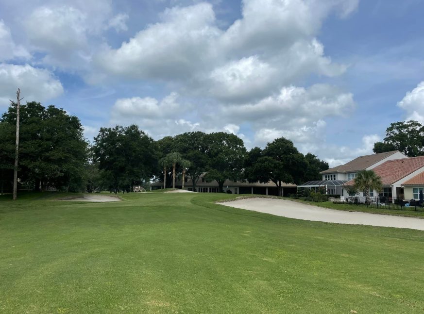 Putting green backed by residences and trees - Sweetwater Golf & Country Club