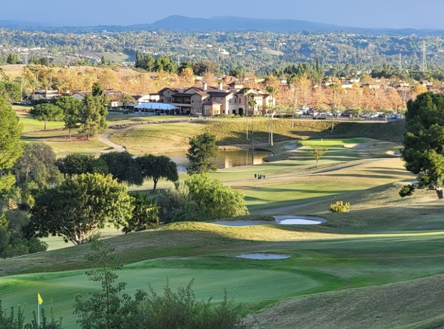 The golf course has a lot of trees and a clubhouse - Aliso Viejo Golf Club