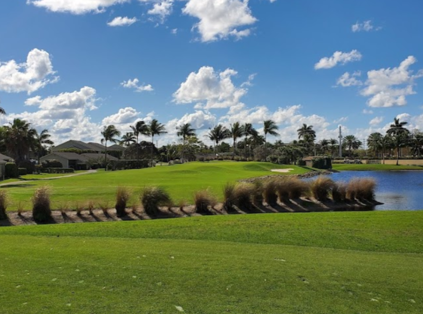 the golf course has trees, houses and a lake - Jupiter Dunes Golf Club
