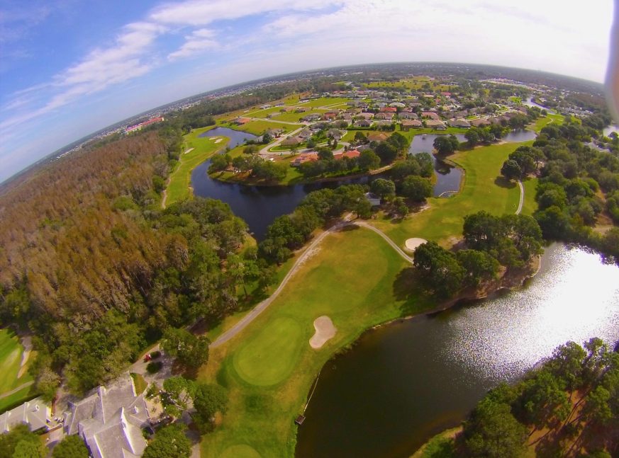 On the top view of the golf course, there are numerous lakes, houses, and trees - Cypress Creek Golf Club at Sun City Center