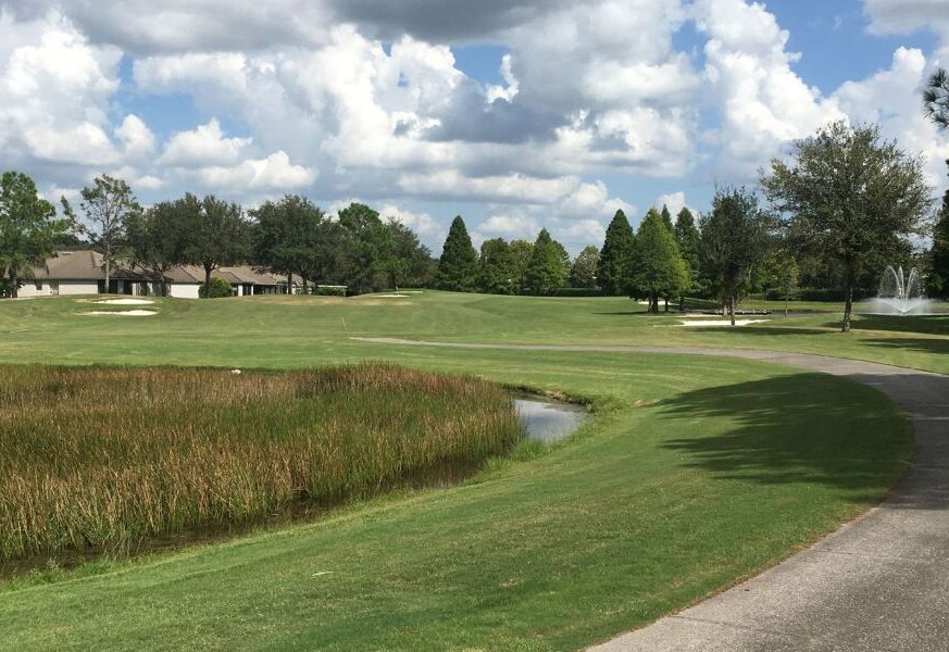 On the golf course, there is a river and a clubhouse - Lexington Oaks Golf Club