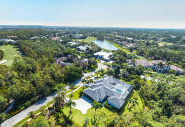 Trees and homes with lake - Quail West Golf and Country Club